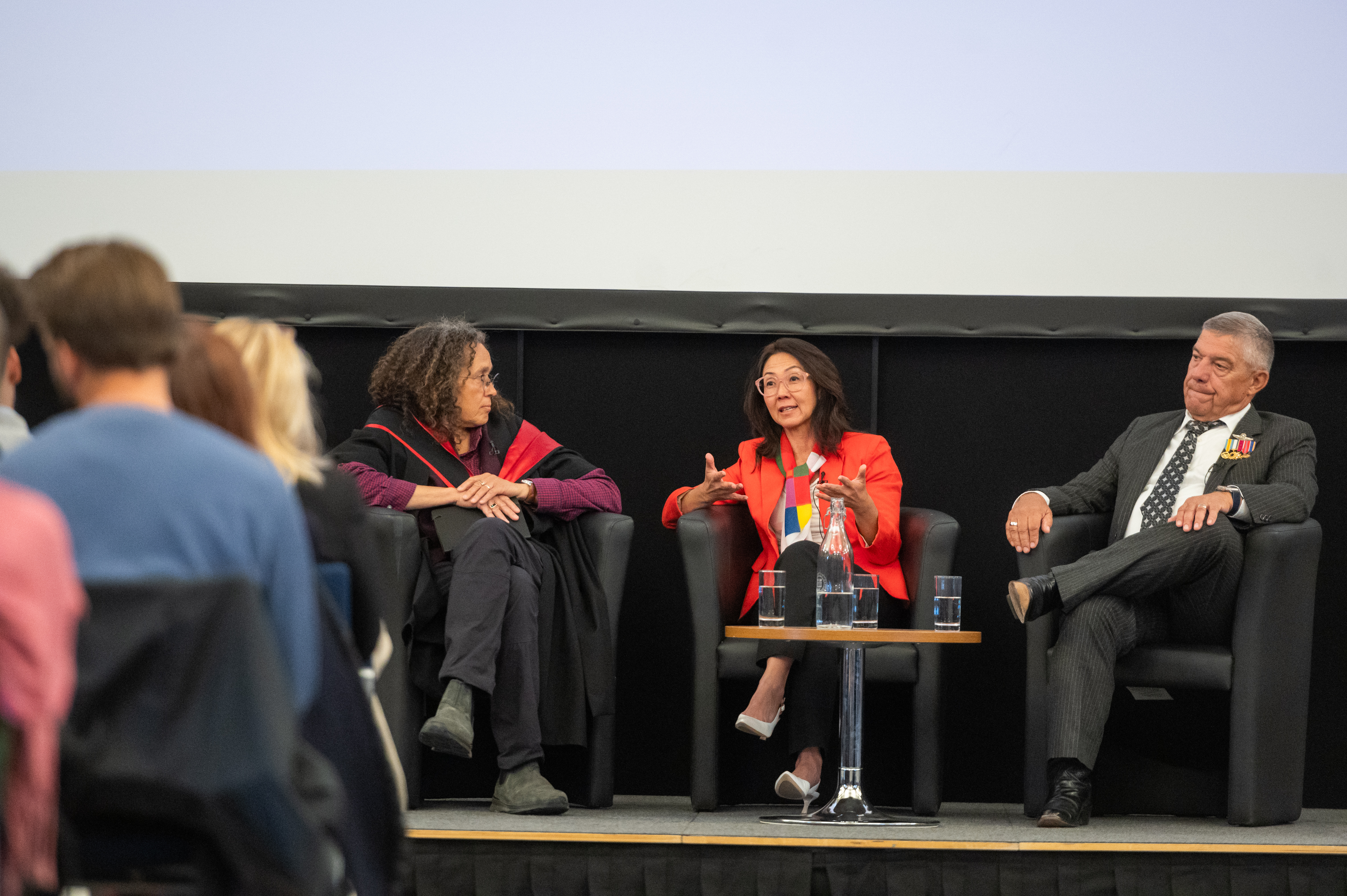 Image of a panel of three people sat in front of an audience
