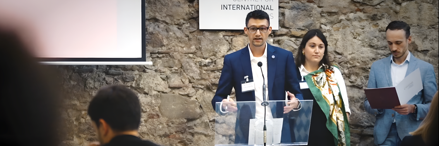 A person standing at a podium with a person standing behind him