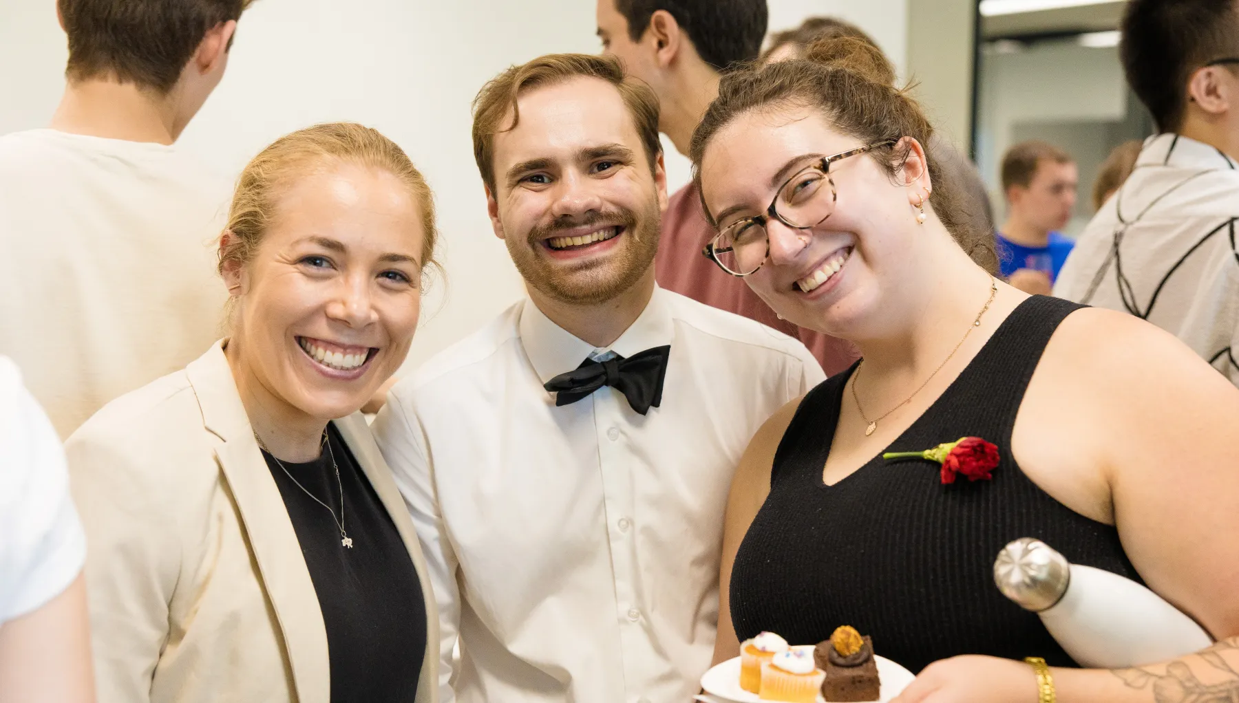 Image of three people stood together smiling at the camera